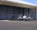 Le costruzioni temporanee della struttura d'acciaio del hangar per aerei con alzano la porta